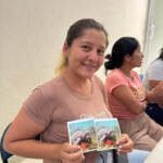 Guardiana azul mostrando fotos de tortuga marina en el taller de liderazgo, género y empoderamiento emocional, en San Cristóbal
