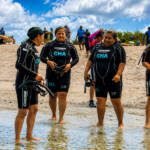 Guardianas azules con trajes de buceo para el taller de habilidades acuáticas y monitoreo comunitario