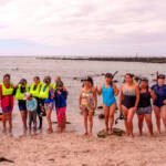Foto grupal de Guardianas azules con instructor de natación Alex Nata, con snorkel en el taller de habilidades acuáticas y monitoreo comunitario en Isla Lobos